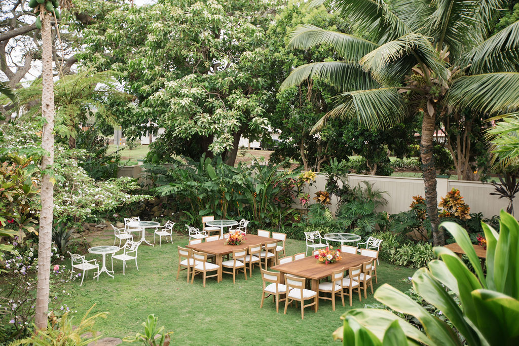 The garden set with long tables and chairs beneath the palms
